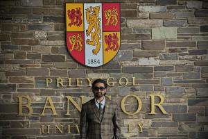 Image of International Student Mentor - Rahul Kumar, with Bangor University logo behind