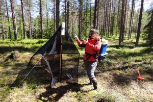 Researcher standing next to a malaise trap in the forest in Sweden