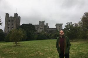 Photograph of Dr Matthew Rowland in front of Penrhyn Castle