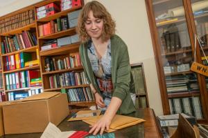 Woman in an archive handling documents