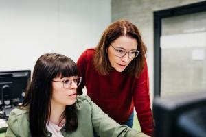 2 people working on a computer.