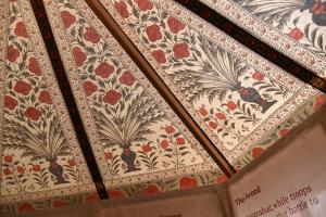 The roof of a tent with an intricate red and black floral pattern.