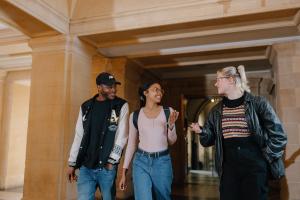 A photo of three students walking through the corridor of Main Arts.