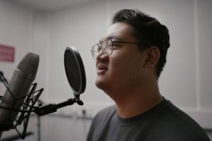 Student speaking into microphone in phonetics labs 