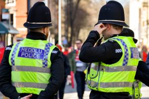 Cardiff, Wales - March 2022: Rear view of two police officers on duty in Cardiff city centre