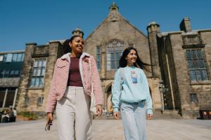 Two students walking away from the Main Arts Building 