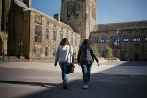 Two students walking towards Main Arts building