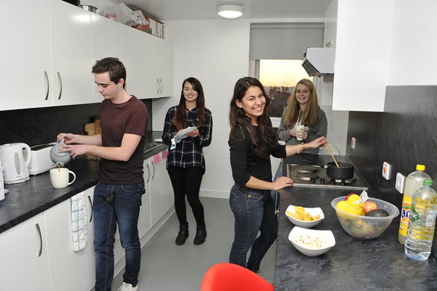 Students cooking in shared kitchen at halls of residence