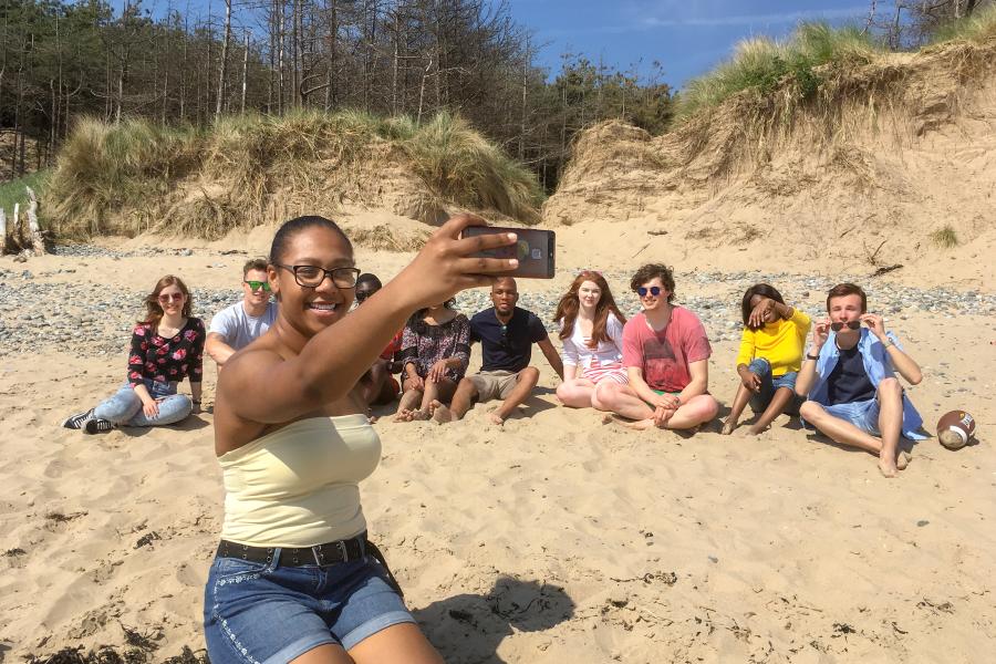 A group of students enjoying the sun, taking a selfie on the beach