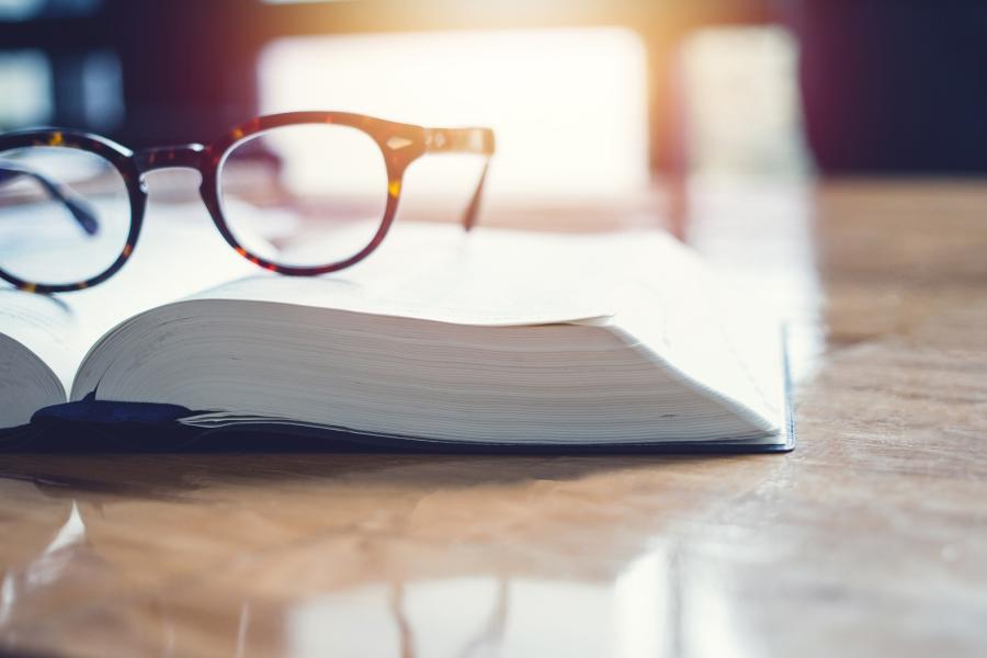 A pair of glasses resting on an open book