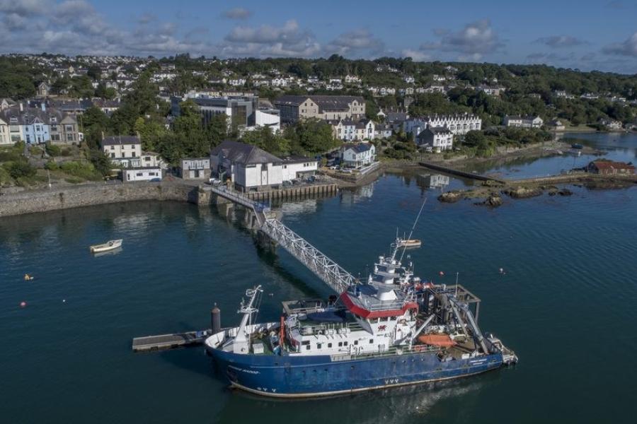 A blue ship lies at the end of Menai Bridge pier, seen from above.