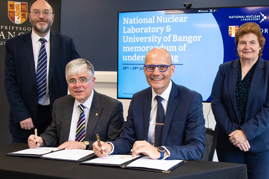 four people signing a document