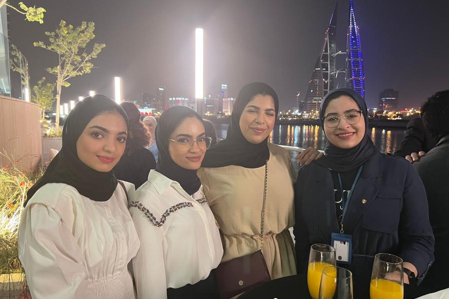 Four alumni smiling at camera during Bahrain reunion 2022