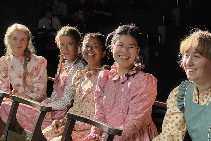 Five young women in frilly dresses 