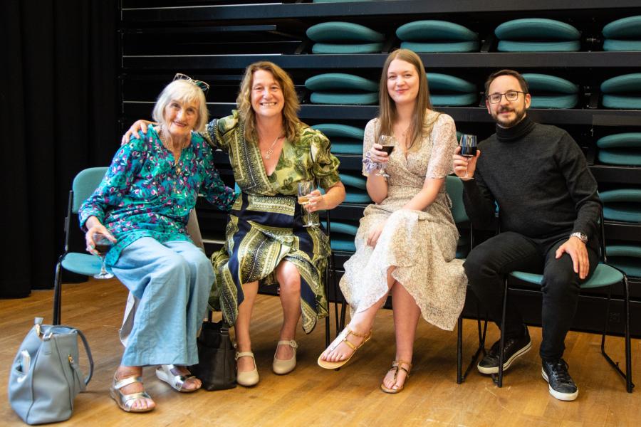 Pedwar gwestai gyda diodydd yn gwenu i'r camera / Four guests with drinks smiling at the camera