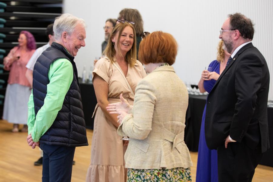 Cyn-fyfyrwyr yn sgwrsio yn ystod y derbyniad / Alumni chatting at the reception