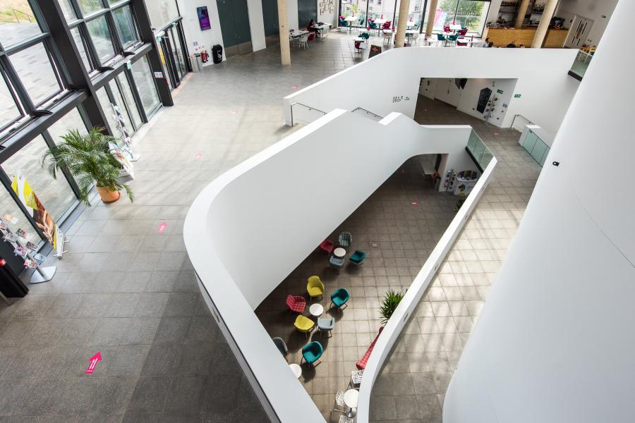 Image of Pontio taken from the 5th floor, looking down on the ground floor, floor one and two capturing the bar on the ground floor and the cafe on the second floor.