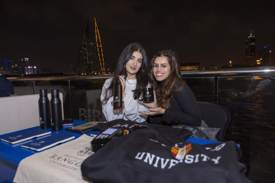 Alumni at Bahrain reunion with Bangor University merchandise
