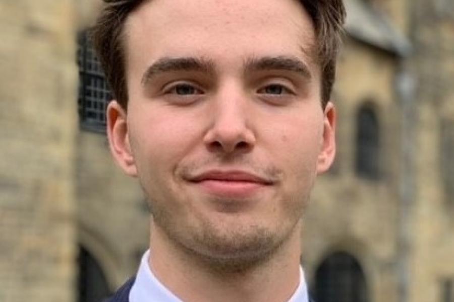 Headshot of Dylan Davies with a blured Bangor University Building in the background