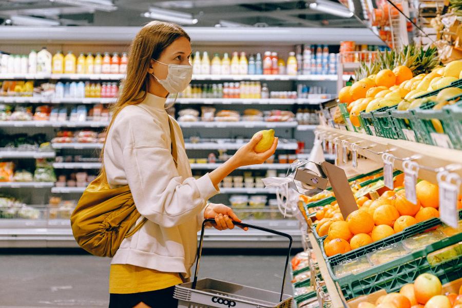 Woman picking out fruit wearing mask