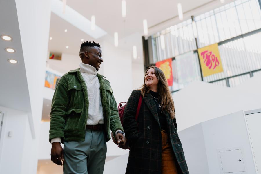 Two students walking whilst chatting to each other 