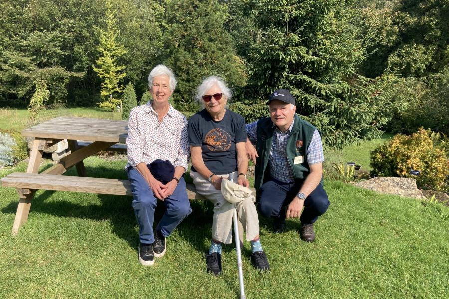 Three people on a picnic bench