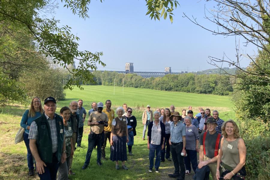 Group of people with Britannia bridge in the background