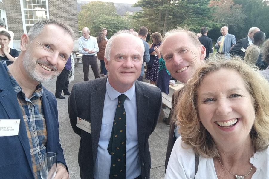 Four alumni smiling on Reichel Terrace