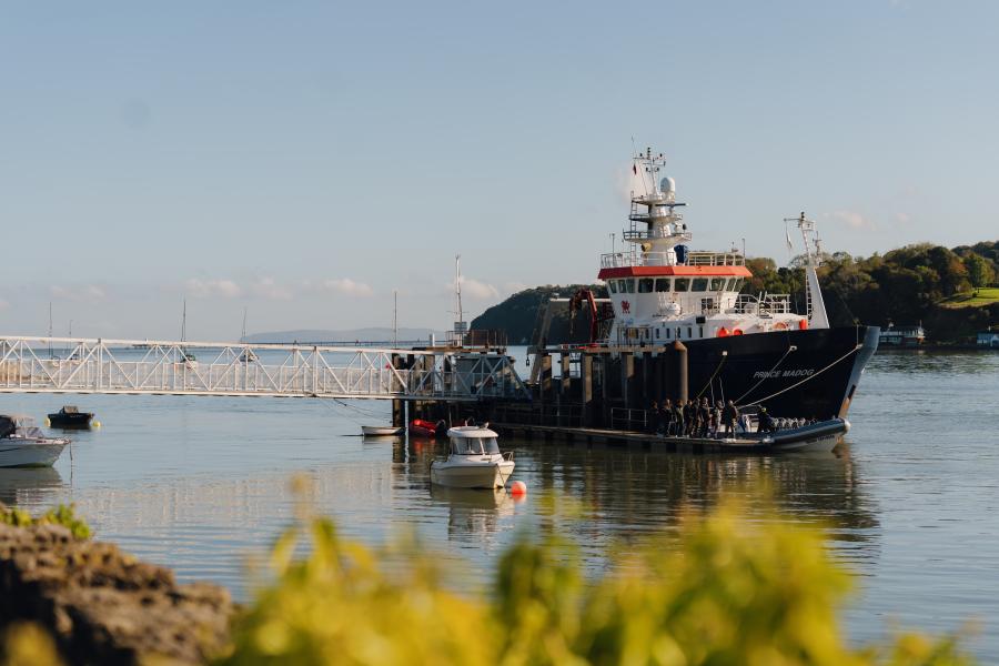 The Prince Madog, the university's research vessel, is docked on the calm Menai Straits on a clear, beautiful autumn day.