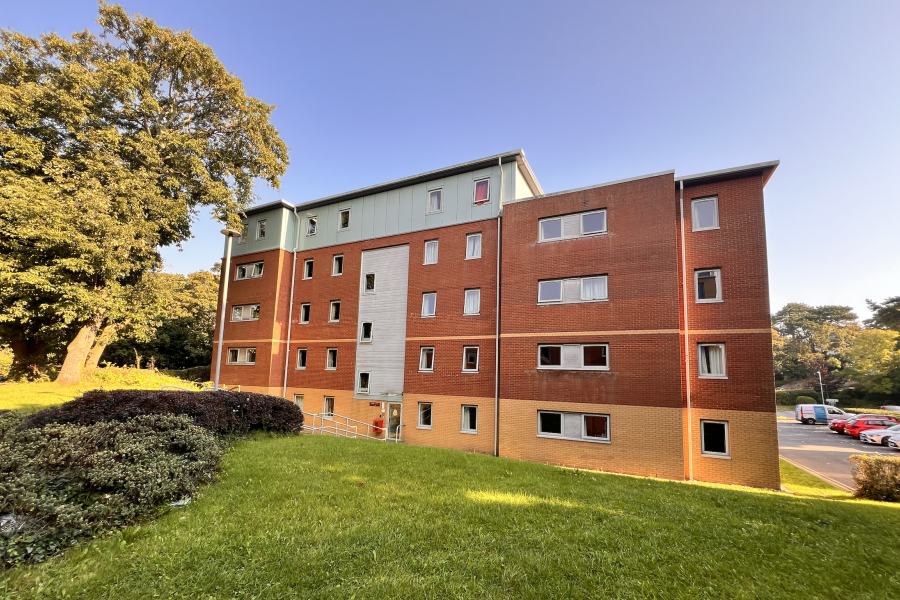 Crafnant Hall, 5 floors, with trees and grass and a blue sky