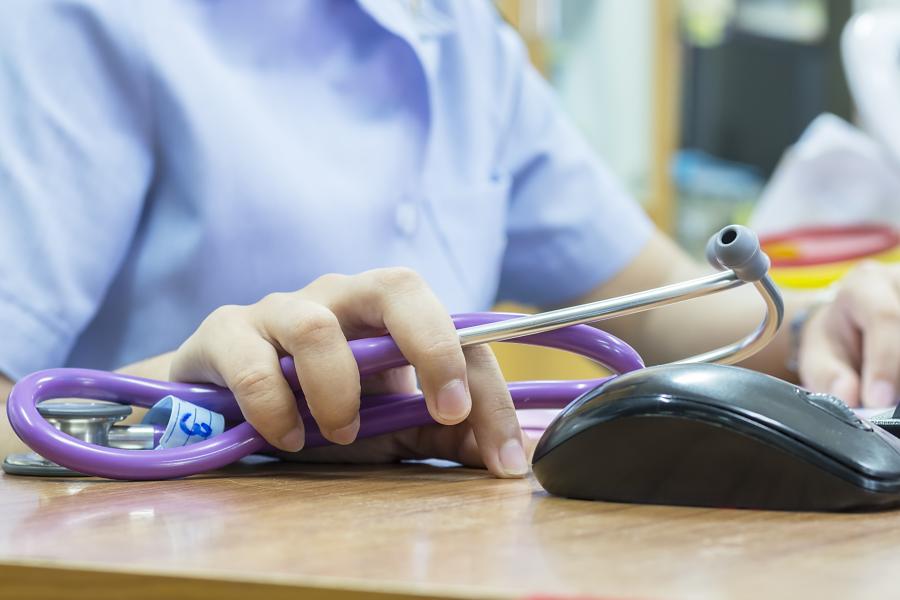 Student with stethoscope and on computer