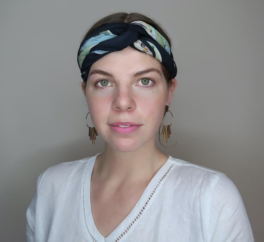 Young woman with headscarf looks into camera