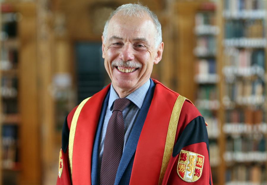 Photo of Caradoc Jones in Bangor University library in graduation gown