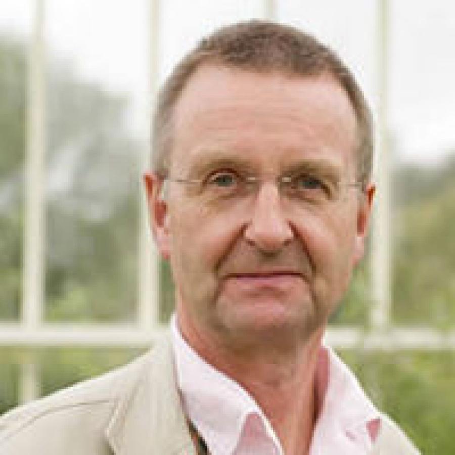 head and shoulders of man looks into camera