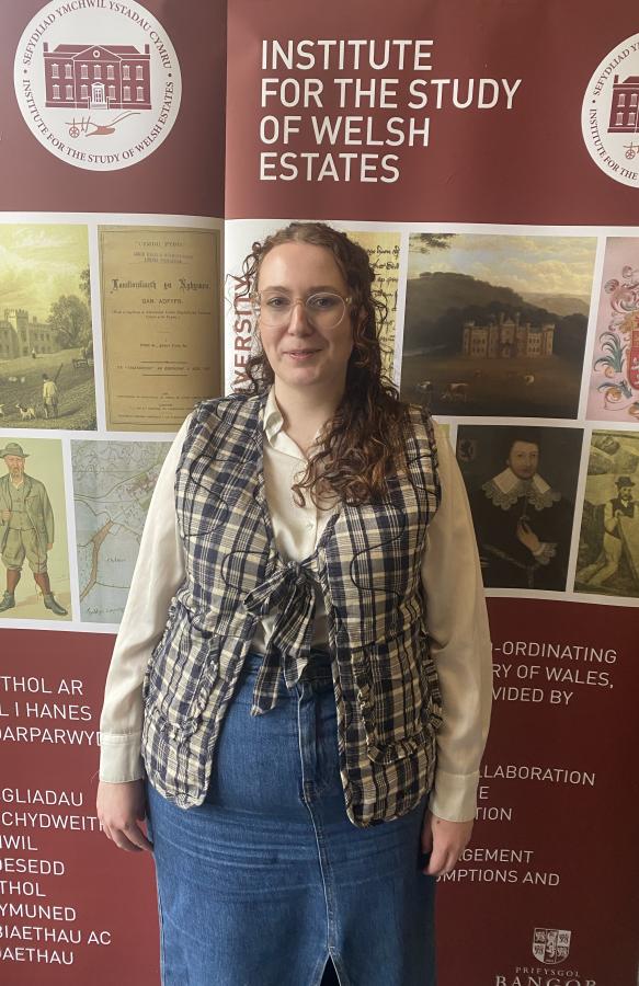 Photograph of Bethan in front of an ISWE banner. 