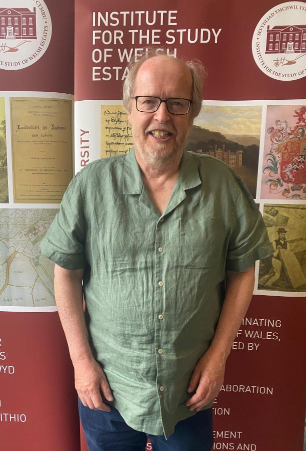 Doctoral Researcher Jeff Childs stands in front of an ISWE banner. 