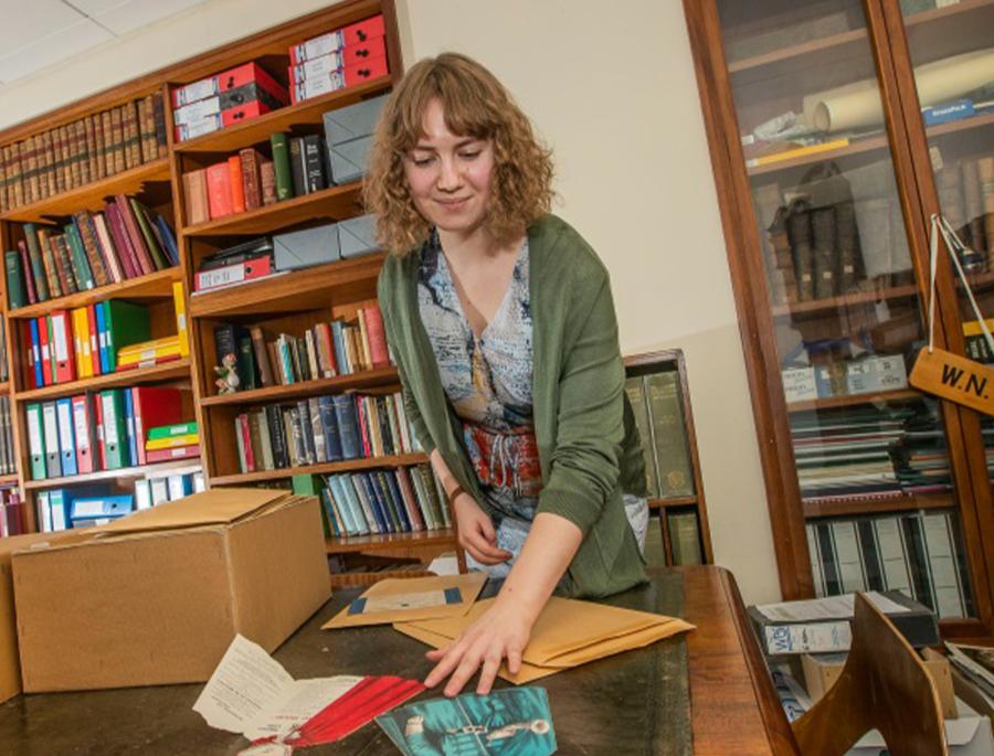 Woman in an archive handling documents