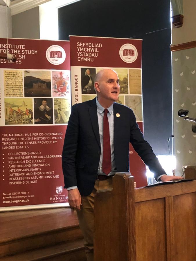 Melvyn Humphreys presenting in front of an ISWE banner. 